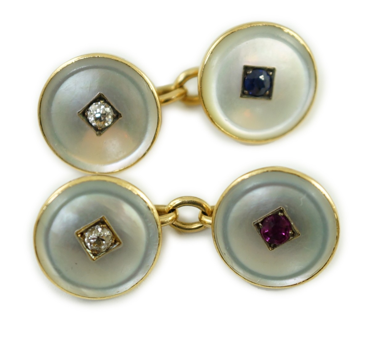 A pair of early to mid 20th century yellow metal mounted mother of pearl and gem set cufflinks, one set with a ruby and diamond, the other with a sapphire and diamond, link diameter 12mm, gross weight 8 grams.